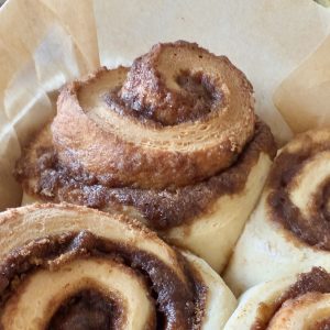 Close-up of an unfrosted freshly baked cinnamon roll with rise of swirl layers of sugar and cinnamon